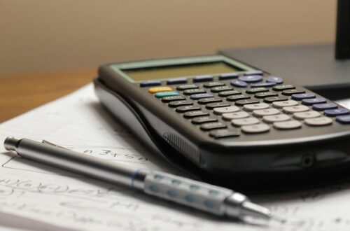 Lommeregner og kuglepen på budgetpapirer – planlægning af sinking funds